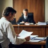 causa contro INPS DURC avvocato esamina documenti in aula di tribunale davanti al giudice